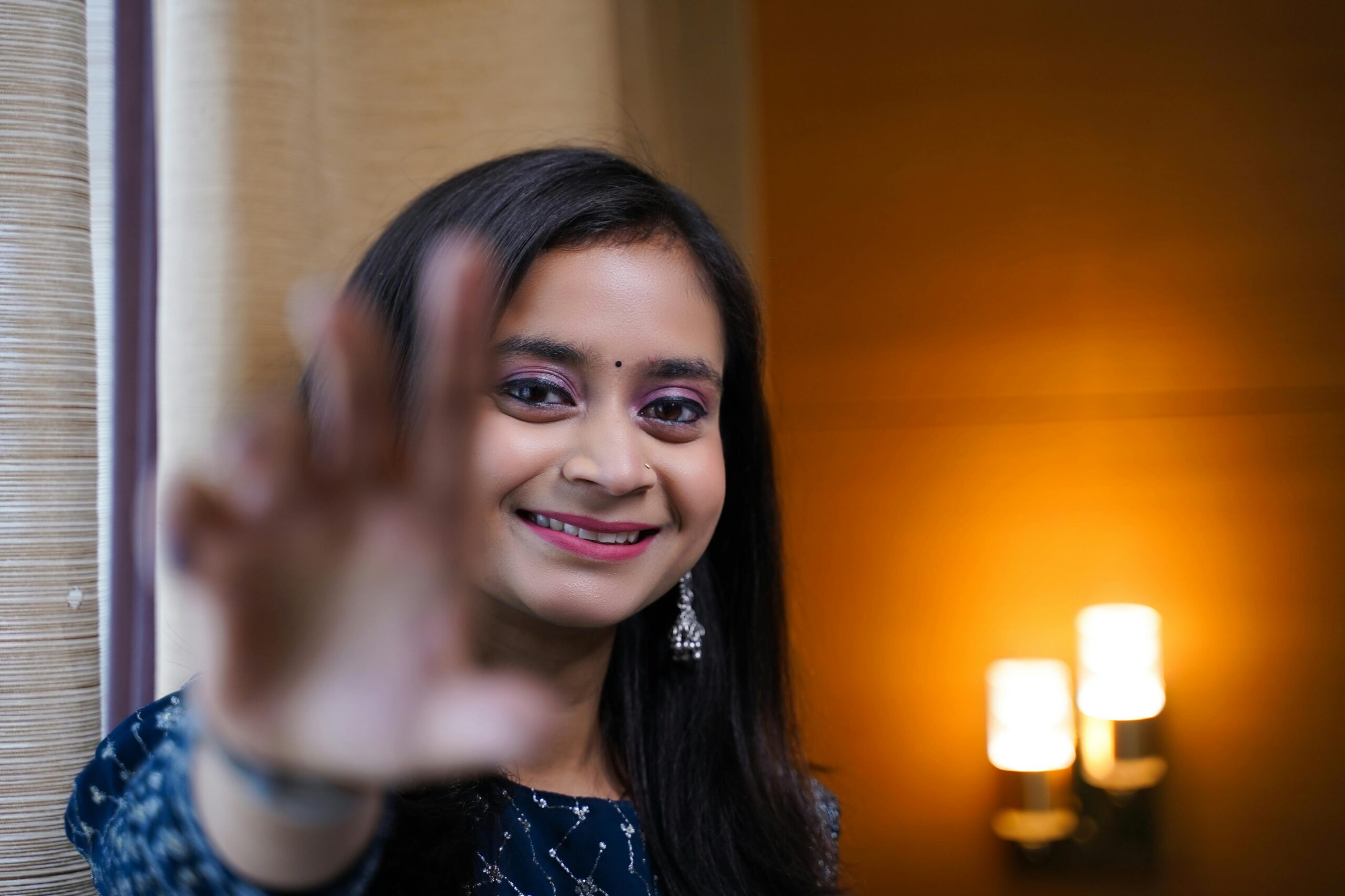 Close-up portrait of a smiling South Asian teenage girl indoors in Varanasi.
